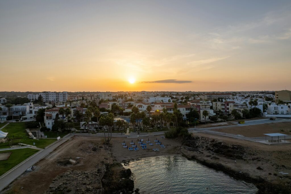 A breathtaking aerial view of Pernera, Cyprus at sunset with its beautiful coastline and vibrant town.